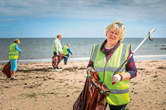 Wendy Murray and fellow volunteers from East Haven Together pick up litter dropped on the beach