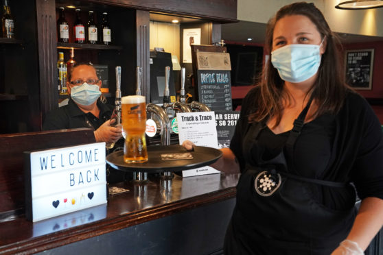 Staff at The Victoria pub in Whitley Bay welcome back customers as they serve the first pints                        post-lockdown down south