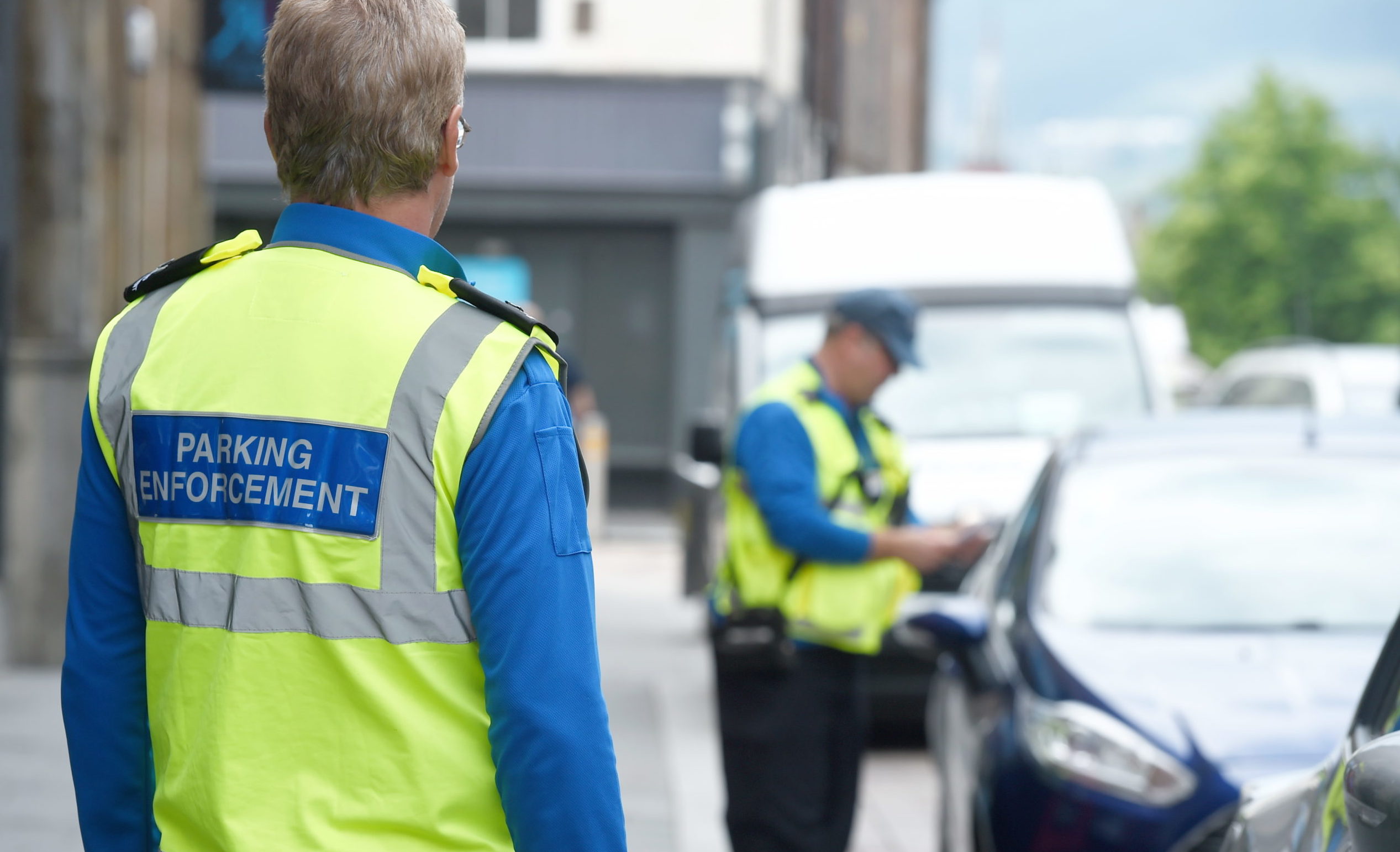A parking officer issues a fixed penalty notice in Inverness