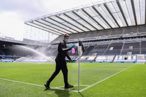 A member of the St James’ Park grounds staff disinfects the corner flag before the Newcastle-Sheffield United match is played behind closed doors last month