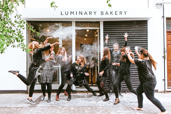 Team members celebrate the success of Luminary Bakery, which helps disadvantaged women and won the Duchess of Sussex’s support