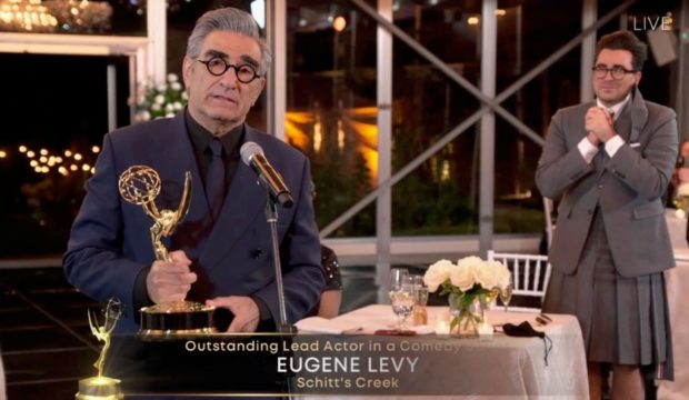 Dan Levy, right, watches as dad Eugene accepts Emmy award