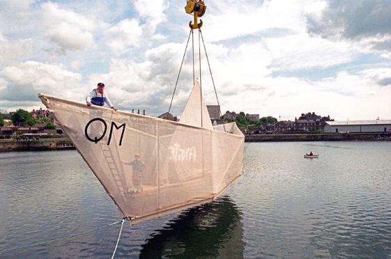 Sculptor George Wyllie's paper boat is craned into the water at the Consafe Shipyard in Burntisland, Fife.