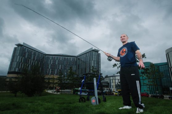 Injured angler Robbie Bell casting his fly rod outside the QEUH in Glasgow