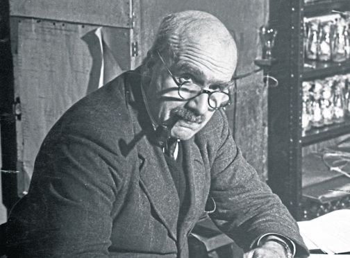 Prof. J. B. S. Haldane sitting at his desk.