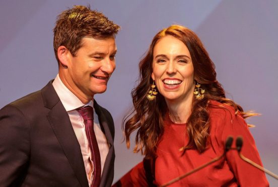 New Zealand Prime Minister Jacinda Ardern (R) and her partner Clarke Gayford celebrate at the New Zealand Labour party election night event in Auckland.