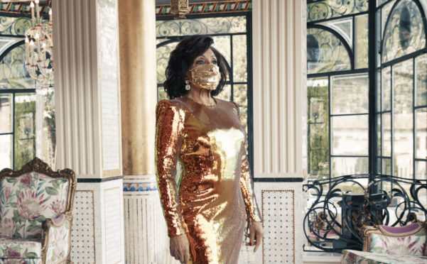 Dame Shirley Bassey, 83, wearing a matching face mask and sequined gold gown during a photo shoot in Italy for her forthcoming new album 'Owe It All To You'
