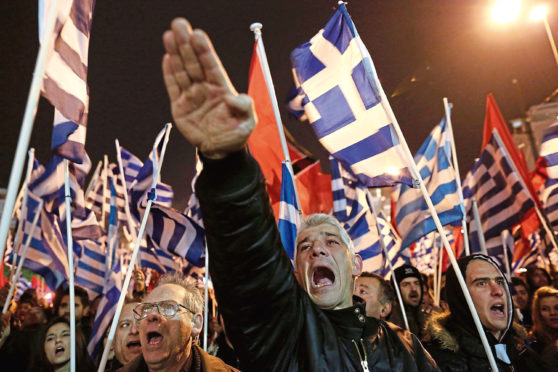 Golden Dawn supporter makes Nazi salute at a rally in Athens.