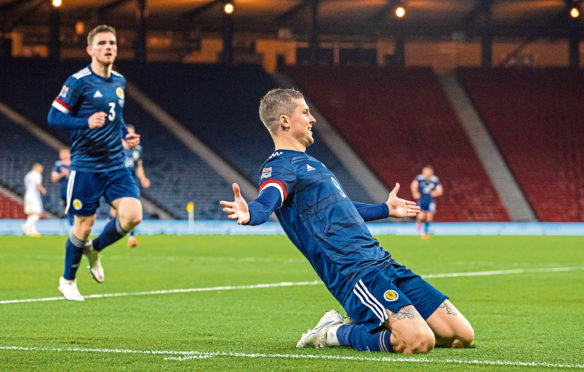 Lyndon Dykes celebrates his goal against Slovakia, but his club manager, Mark Warburton, was unhappy with his amount of game time for Scotland.