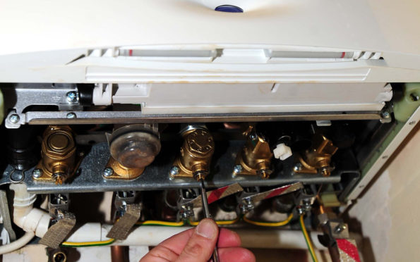 A plumber working on a gas boiler