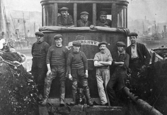A fishing crew on board the Kirkcaldy-registered vessel Pursuit in the early 1900s, kitted out in jerseys