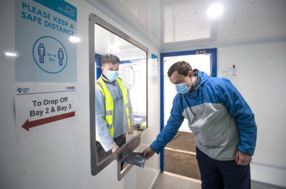 Andrew Ilesley collects a self-test kit during a  demonstration on how to use the new walk-through Covid testing centre in Dundee