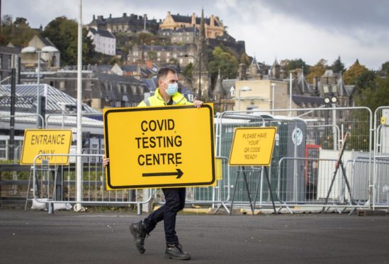 Jim Connell sets up signs at a new walk-through Covid test centre at The Engine Shed, Stirling, which opened to the public this weekend