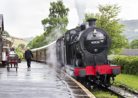 steam train trundles into Oakworth station on the Keighley and Worth Valley heritage line as featured in the reboot of All Creatures Great And Small