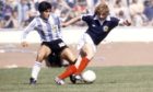 Argentina's Diego Maradona (left) with Asa Hartford in a Scotland v Argentina friendly.