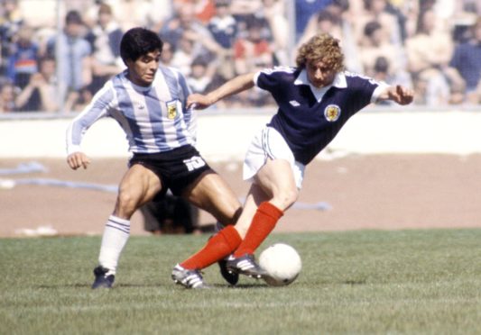 Argentina's Diego Maradona (left) with Asa Hartford in a Scotland v Argentina friendly.