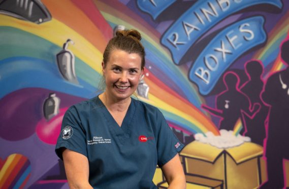 Nurse Alison Williams in front of Rainbow Boxes mural