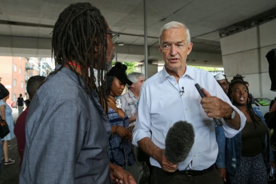 Newsreporter Jon Snow for ITN interviews local residents of Grenfell Tower.