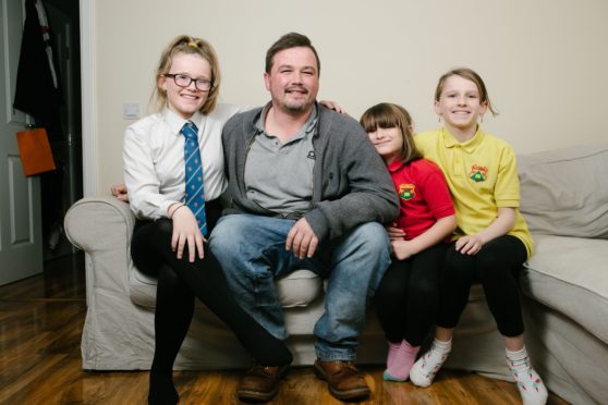 Richard Neville at home in Paisley with daughters, from left, Katie, 13, Sophie, 7, and Holly, 10