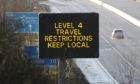 A traffic information board as traffic flows on the M80 near Banknock, Scotland