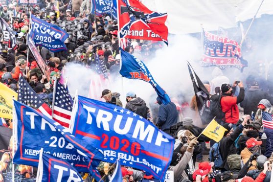 Smoke rises after explosure police used pepper-spray ball gun against Pro-Trump protesters rally around Capitol building before they breached it and overrun it on Jan 6.