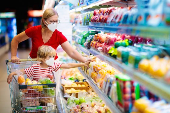 A mother and her little boy buy fresh vegetables in a supermarket. One store manager said groups of people are coming in for a chat in the aisles