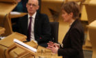 Deputy First Minister and Education Secretary John Swinney watches First Minister Nicola Sturgeon as she delivers a statement at Holyrood,