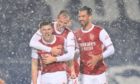 Kieran Tierney celebrates scoring against West Brom in his short-sleeves in the snow