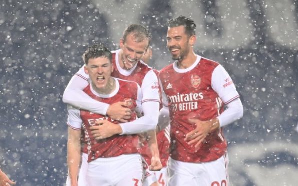 Kieran Tierney celebrates scoring against West Brom in his short-sleeves in the snow