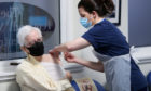 John Elphinstone receives the Oxford/AstraZeneca coronavirus vaccine, administered by Practice Nurse Marianne Stewart, at Pentlands Medical Centre in Edinburgh