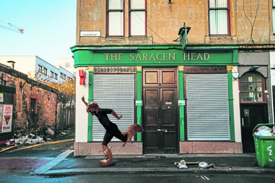 How a statue of Billy Connolly might look when, in a pose inspired by his iconic Get Right Intae Him album, he is seen at street level outside the pub where his famous Crucifixion routine was set.