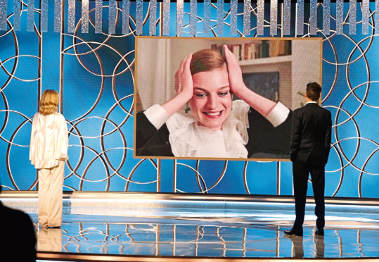 Emma Corrin (c) accepts the Best Television Actress - Drama Series award for 'The Crown' via video from Kyra Sedgwick (l) and Kevin Bacon at the 78th Annual Golden Globe Awards held at the Beverly Hilton Hotel.