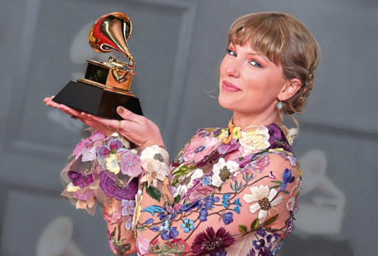 Taylor Swift poses with the award for album of the year for Folklore at the 63rd annual Grammy Awards