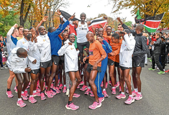 Eliud Kipchoge celebrates breaking the two hour barrier for a marathon distance with supporters and his team on the Hauptallee.