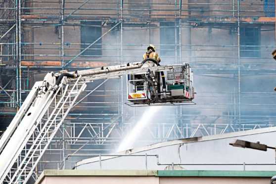 June 2018: Firefighters damp down Glasgow School of Art on the day after devastating blaze.