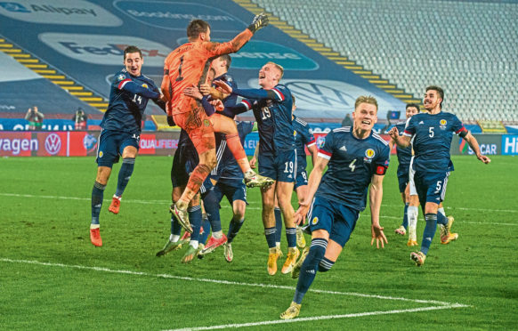 David Marshall is hailed by his jubilant teammates after his save against Serbia in November puts Scotland into this summer’s Euros