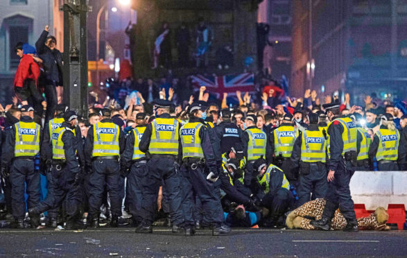 Police detain a man as Rangers fans gather at George Square in Glasgow on March 7.