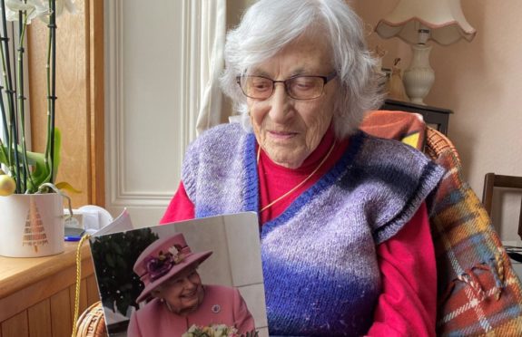 Annie Whyte reads the 100th birthday card sent to her by the Queen