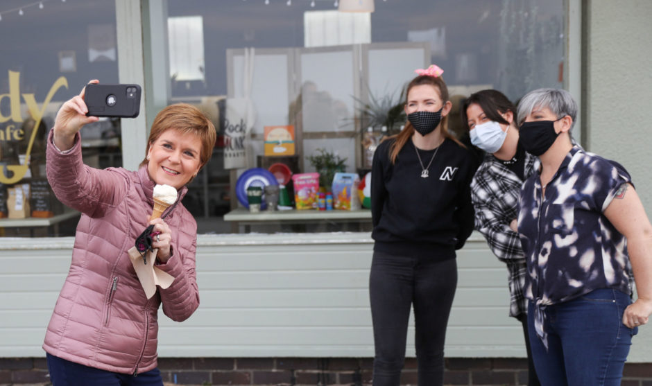 Nicola Sturgeon gives a check-up to "Dentosaurus" during a visit t Thornliebank Dental Care