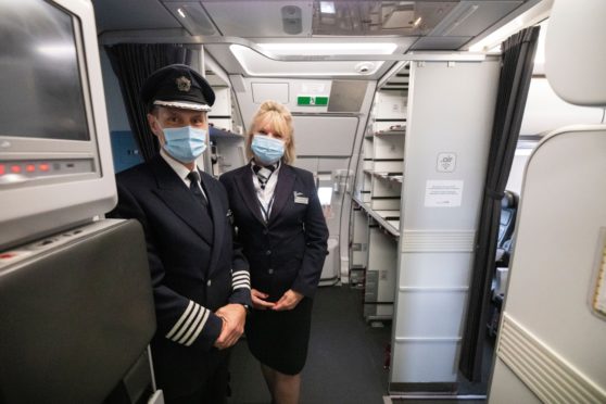 Aircrew wear masks to welcome passengers back on board as Which? warns travellers to check their travel insurance cover