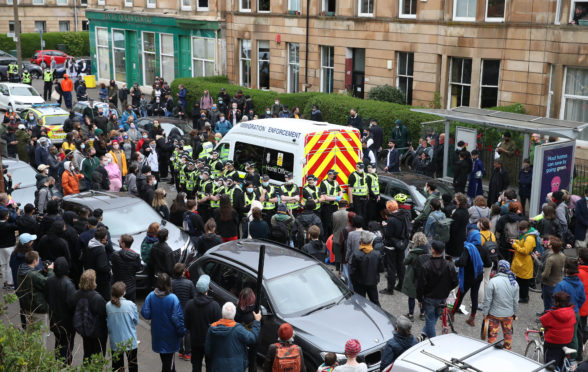 Protesters block an immigration van in Glasgow following a dawn raid in Pollokshields.