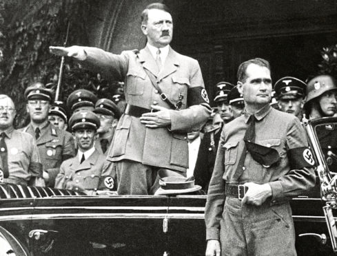 Then German Chancellor Adolf Hitler and his personal representative Rudolf Hess, right, during a parade in Berlin, Germany.
