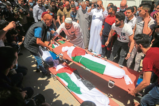 Mourners react next to bodies of Palestinians who were killed amid a flare-up of Israeli-Palestinian violence, during their funeral at the Beach refugee camp, in Gaza City.