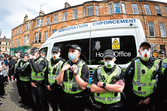 Protestors block an UK home office immigration enforcement van after an attempted raid was carried out in the morning in Kenmure Street in Pollokshields on May 13, 2021 in Glasgow, Scotland.