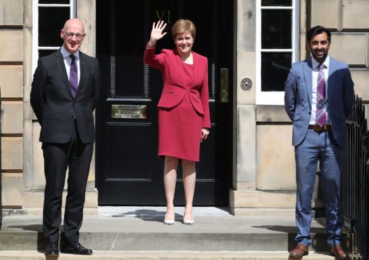 First minister Nicola Sturgeon waves on the steps of Bute House in Edinburgh alongside John Swinney and Humza Yousaf after announcing her new cabinet