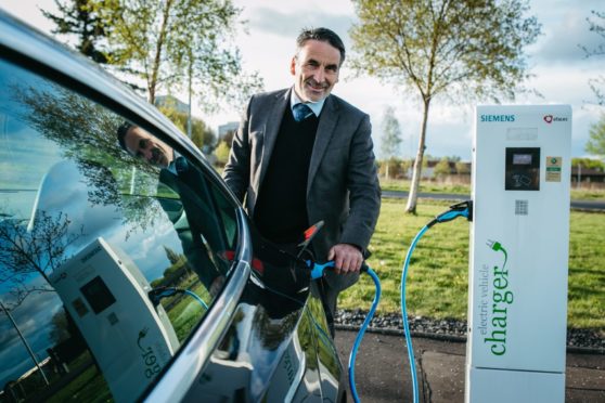 Tesla driver Ron Mackenna powers up his Tesla at a charging point in Glasgow