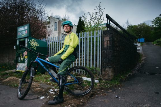 Mountain biker Ruairidh MacKenzie out side St Martin's Church in Castlemilk, Glasgow, which was meant to be turned into a mountain bike hub, as a legacy project after the Commonwealth Games in Glasgow.