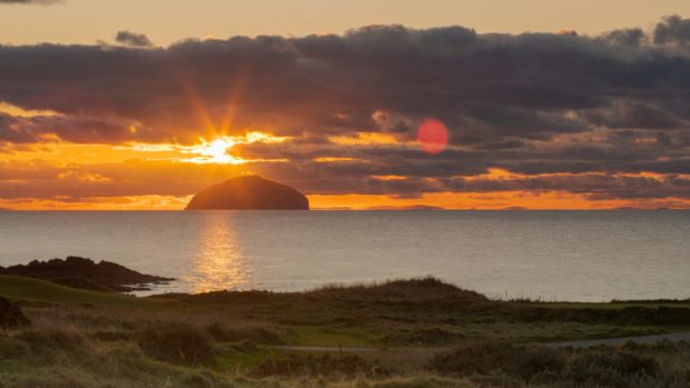 The sun sets behind Ailsa Craig, just off the Ayrshire coast
