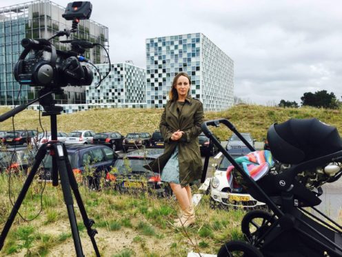 BBC foreign correspondent Anna Holligan reports live to camera from the International Criminal Court in The Hague with daughter Zena in baby buggy just out of shot