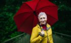 Actress, Blythe Duff shelters from the rain in a park in Cambuslang, Glasgow